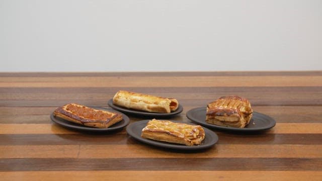 Four kinds of apple pies neatly plated on a wooden table