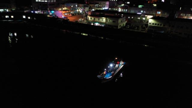 Nighttime View of a Fishing Boat Near the City