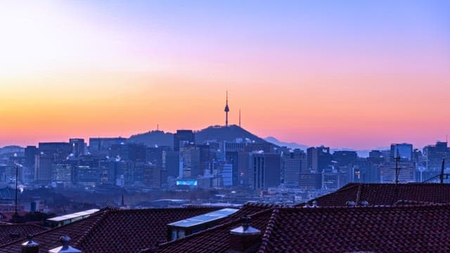 Sunrise over a city skyline with mountains in the background
