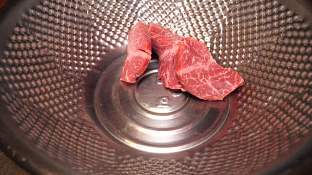 Mixing Garlics and Soy Sauce with Beef Slices in a Bowl