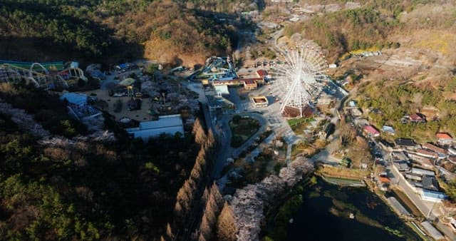 Amusement park near a lake surrounded by forests