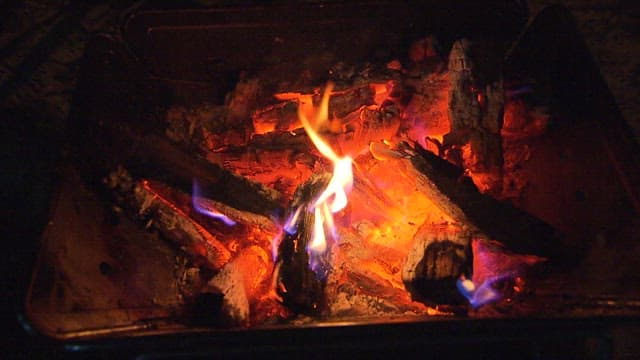 Glowing and burning ember in a cozy fireplace