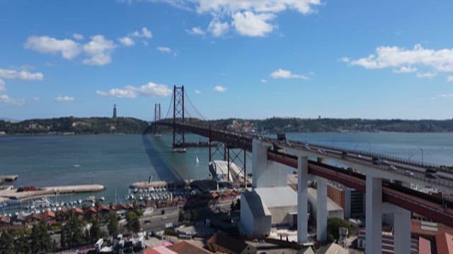 Scenery of a Tranquil River and Red Bridge Under the Blue Sky