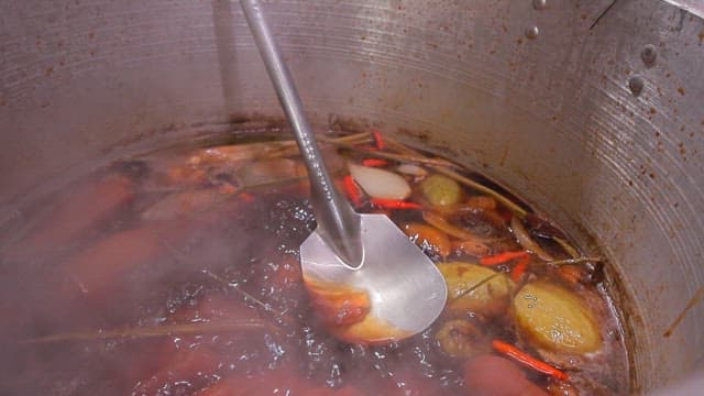 Boiling vegetables and spices in a large pot to make broth