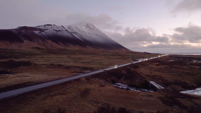 Mountain road with cars at dusk