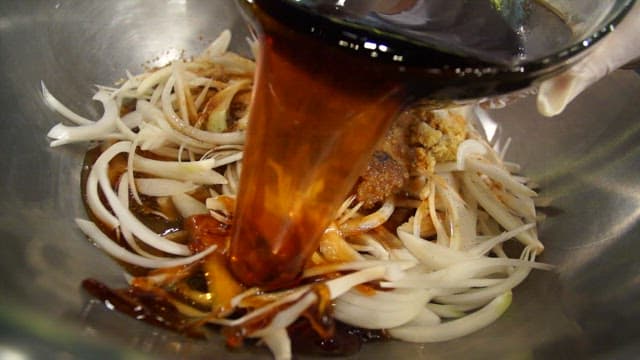 Soy sauce being poured over sliced onions