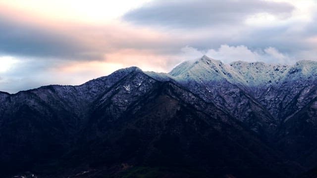 Snow-covered mountains under cloudy skies
