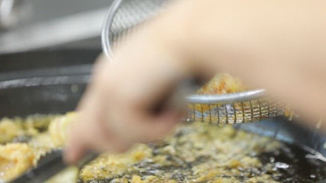 Fried pork being removed from hot oil
