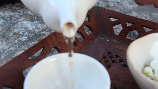 White Petals Floating in a Full Teacup