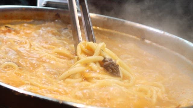 Noodles Being Stirred in a Pot of Boiling Hotpot Soup
