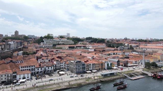 Busy riverside city with red-roofed buildings