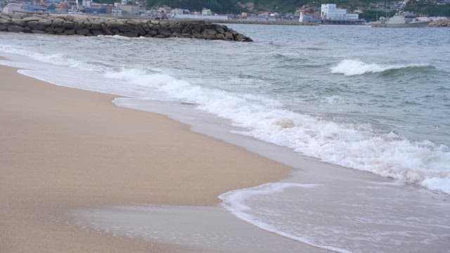 Gentle Waves Crashing onto a Sandy Beach