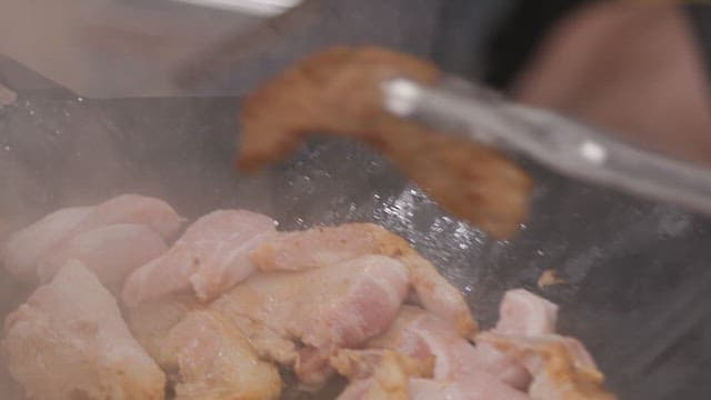 Meat and mushrooms grilling on a pan