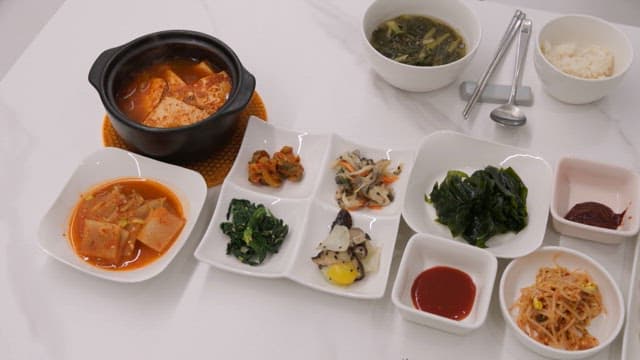 Various Korean dishes arranged on a white table