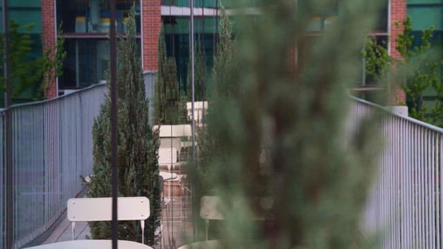 Empty outdoor seating area with flower pots and railings