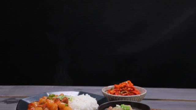 Table with julienne Korean radish salad, rice bowls, and soup
