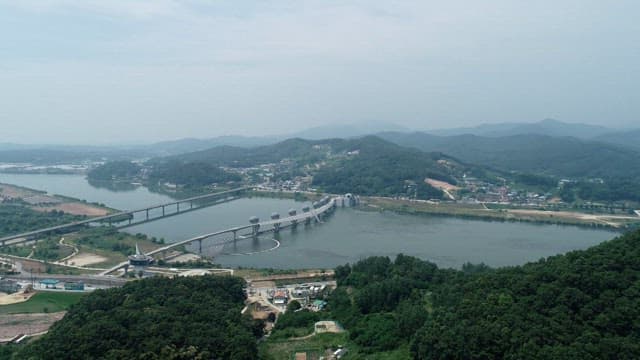 A river with a bridge and surrounding hills