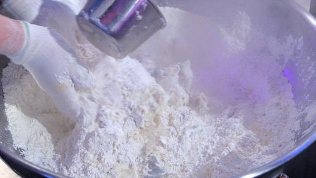 Mixing flour in a large bowl with hands