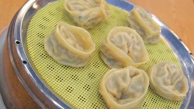 Steamed dumplings plated in a steamer on the table