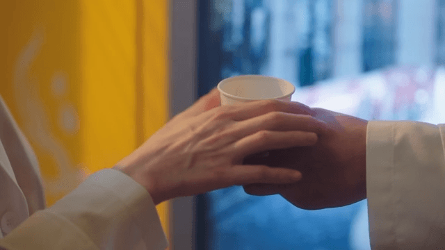 Hand Giving Coffee from Vending Machine