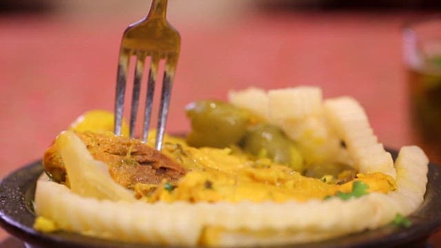 Delicious chicken leg being picked up with a fork