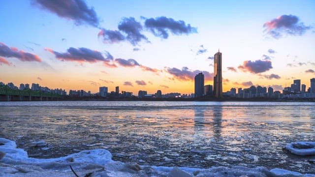 Sunset over a frozen river with the city skyline