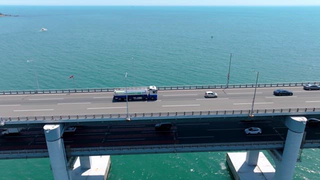 Vehicles crossing a Gwangan Bridge over the calm sea on a clear day