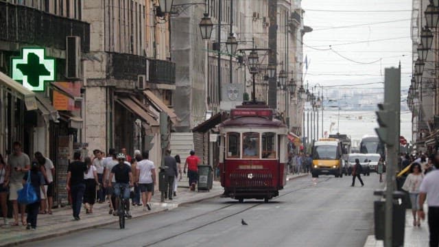 Bustling City Street With Tram And Pedestrians