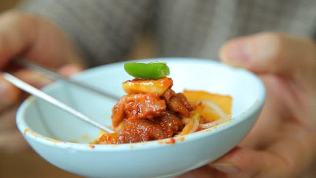 Chopstickful of duck bulgogi with kimchi and bean sprouts