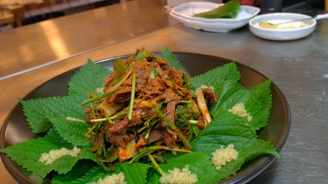 Seasoned meat plated with perilla leaves in the kitchen