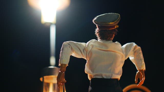 Puppet dressed in sailor uniform under a streetlight at night
