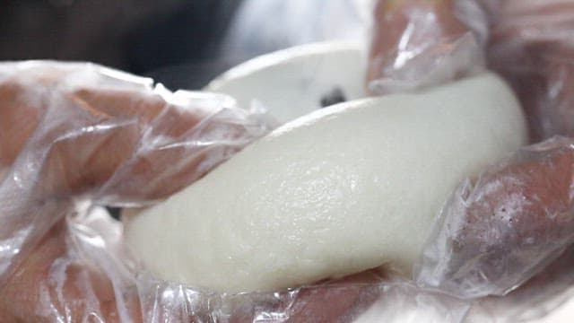 Steamed bun cut in half to reveal red beans inside