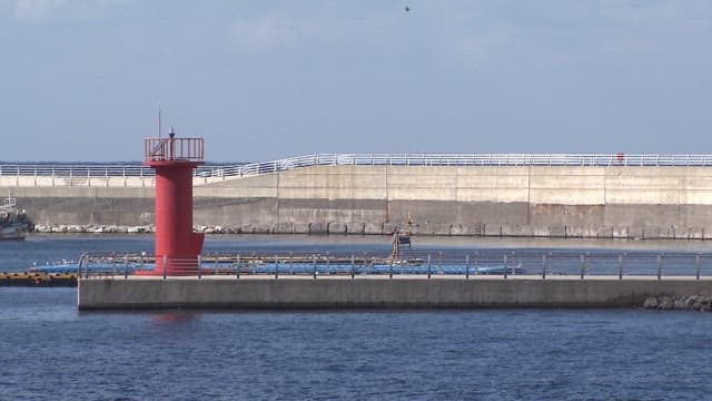 Red lighthouse on industrial pier