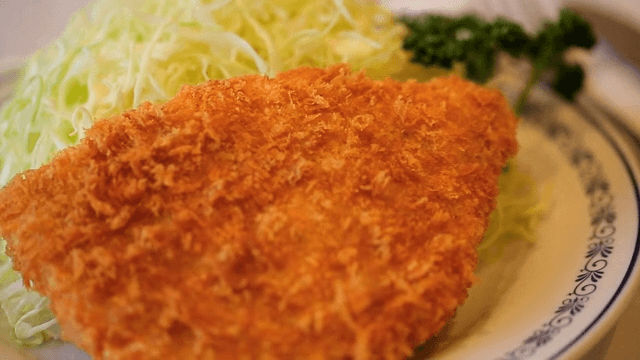 Plate of crispy fried pork cutlet with salad