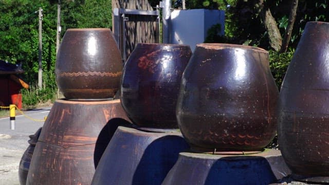 Large traditional pots aligned outside on a sunny day