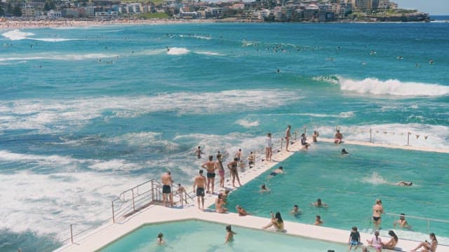 People Enjoying Water Fun in a Beach Pool on a Sunny Day