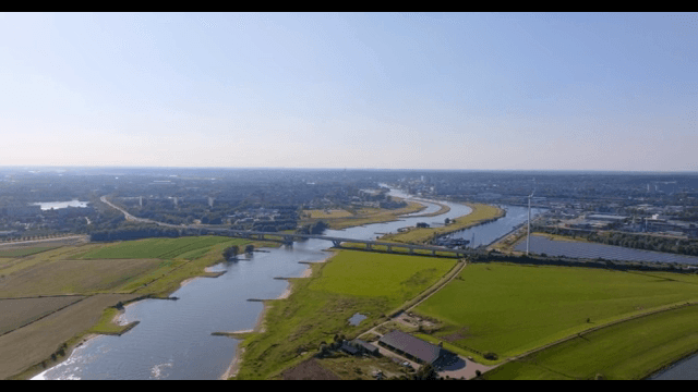 Scenic view of a river with wind turbines