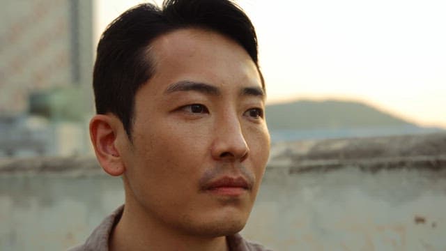 Man smiling on a rooftop at sunset