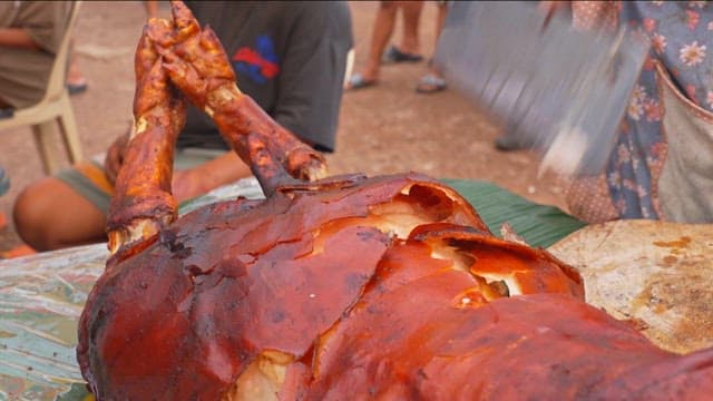 Lechon Baboy being sliced on a wooden board