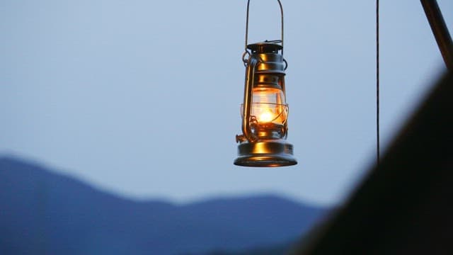 Hanging lantern glowing in the twilight outdoors