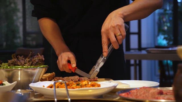 Preparing a meal with grilled meats and salads