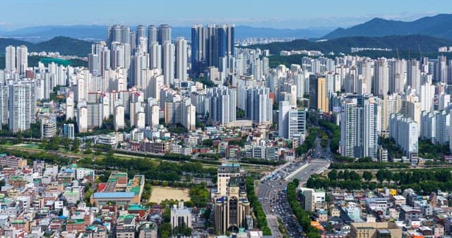 Busy traffic in downtown in Daegu with densely packed buildings at noon