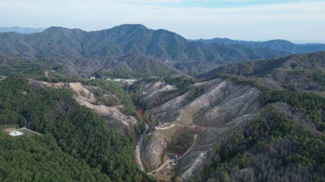 Expansive mountainous landscape with forested valleys in daytime