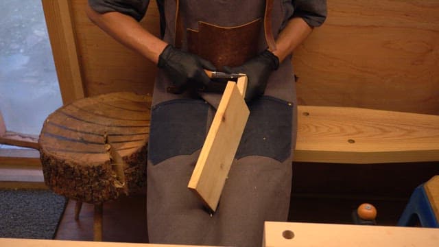 Craftsman carving wood in a workshop