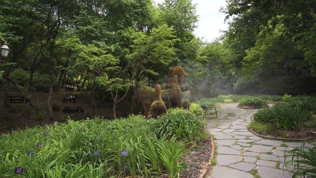 Serene Park with Topiary Animals and Visitors
