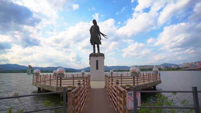 Statue of a woman by the river on a sunny day