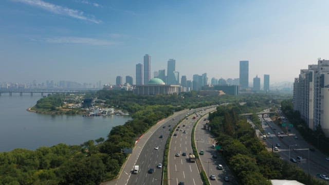 Busy Road in Riverside City with Building Skyline
