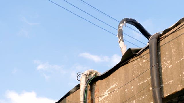 Sky with power lines and rooftops visible