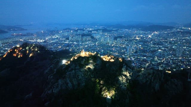 Cityscape with illuminated mountains at dusk