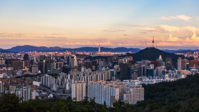Panoramic view of a bustling city transitioning from sunset to night.